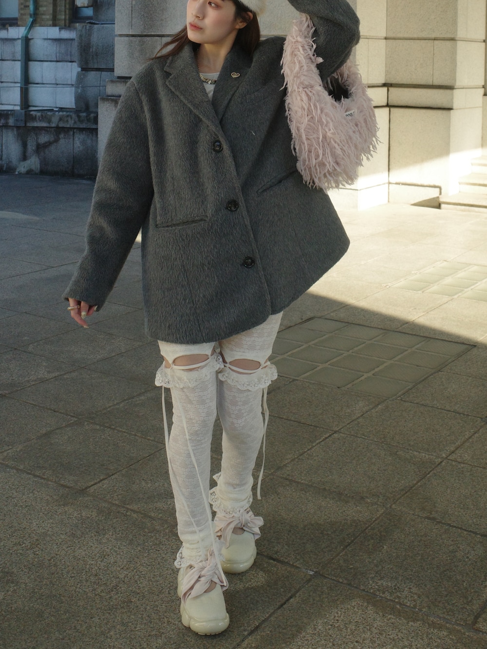 グレー系のテーラードジャケット、ピンク系のショルダーバッグ、ホワイト系のシューズを着用したレディースの秋コーディネートの4枚目の写真