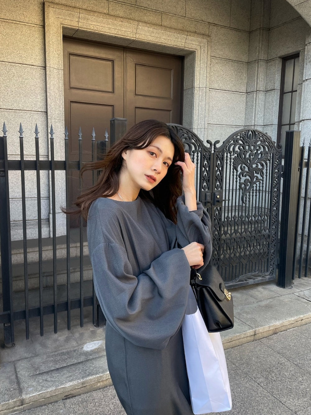 グレー系のワンピースを着用したレディースの秋コーディネートの2枚目の写真