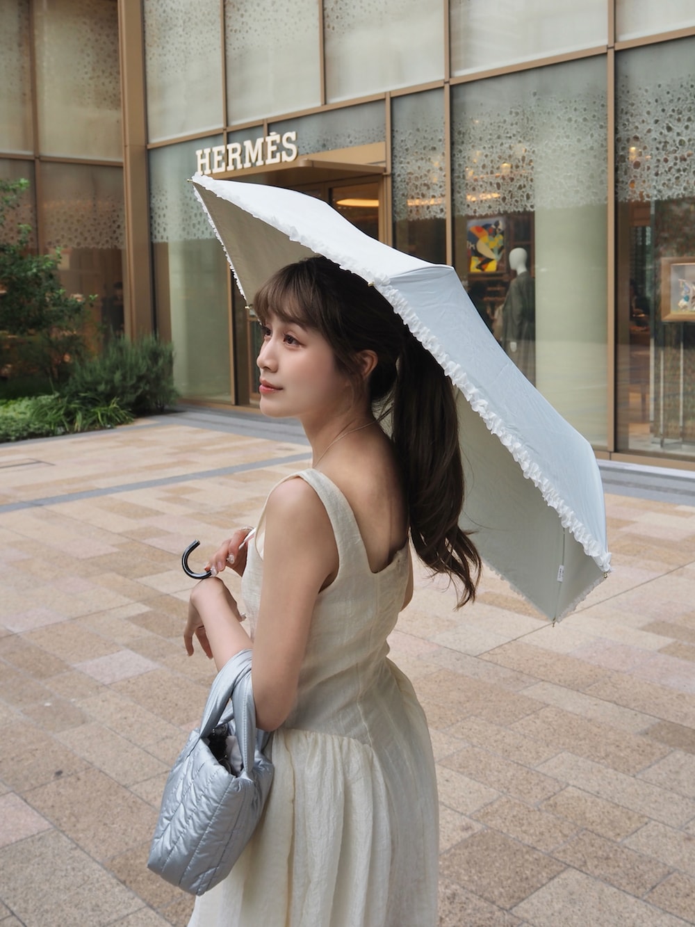 シルバー系のパンプス、ホワイト系のワンピース/ドレスを着用したレディースの夏コーディネートの2枚目の写真