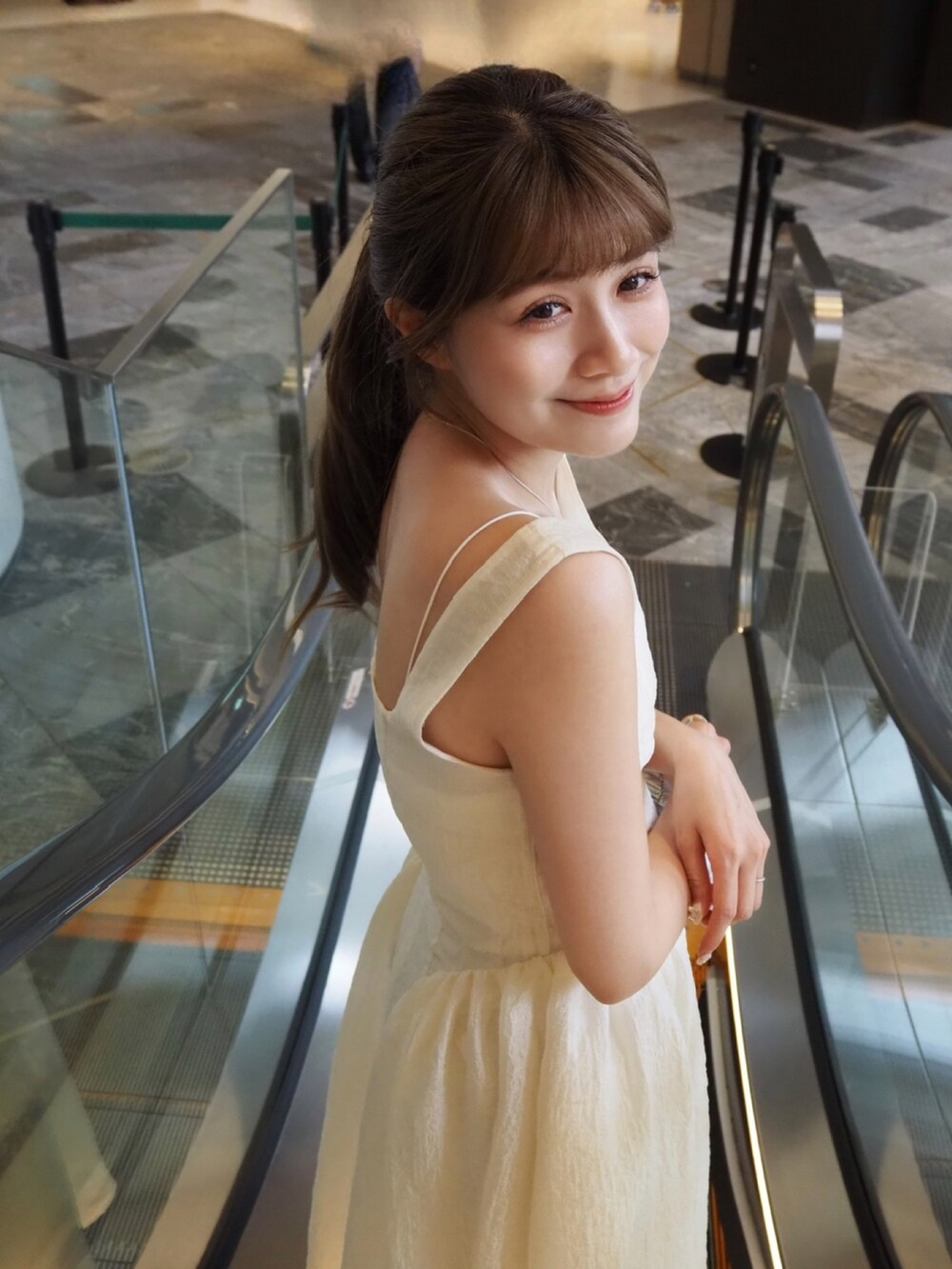 シルバー系のパンプス、ホワイト系のワンピース/ドレスを着用したレディースの夏コーディネートの3枚目の写真