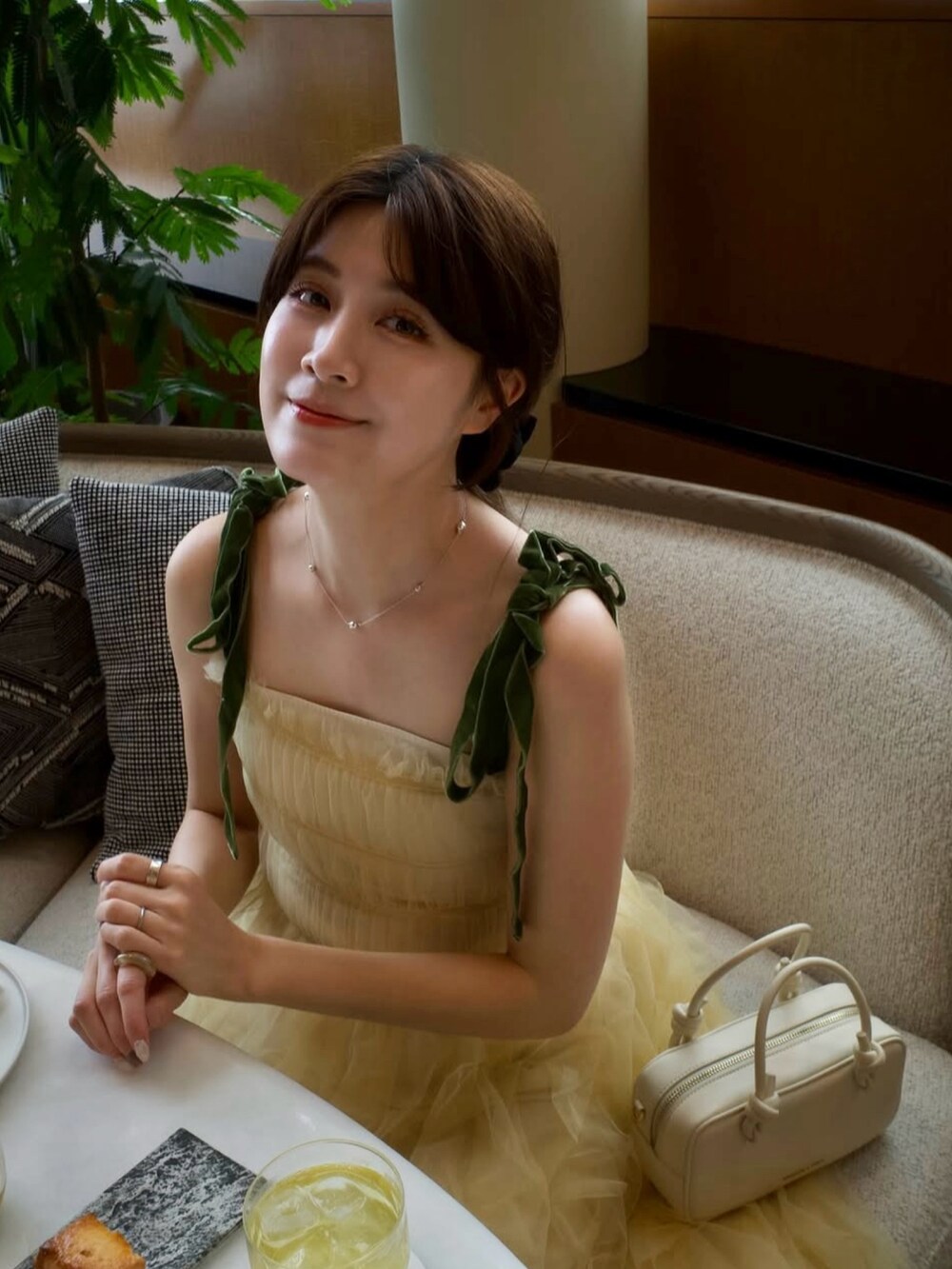 イエロー系のワンピース、ベージュ系のトートバッグ、ブラック系のシューズを着用したレディースの春コーディネートの3枚目の写真