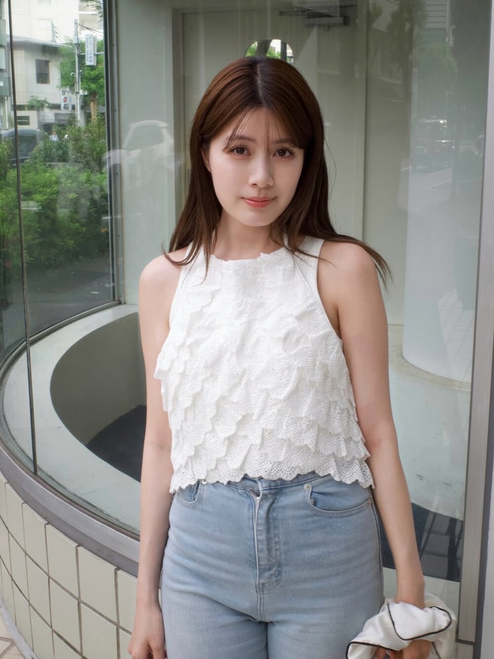 ホワイト系のトップス、ブラウン系のバッグ、ベージュ系のサンダルを着用したレディースの夏コーディネートの2枚目の写真