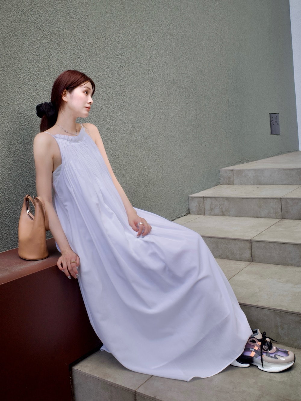 ホワイト系のワンピース、ブラウン系のバッグ、ベージュ系のスニーカーを着用したレディースの夏コーディネートの2枚目の写真