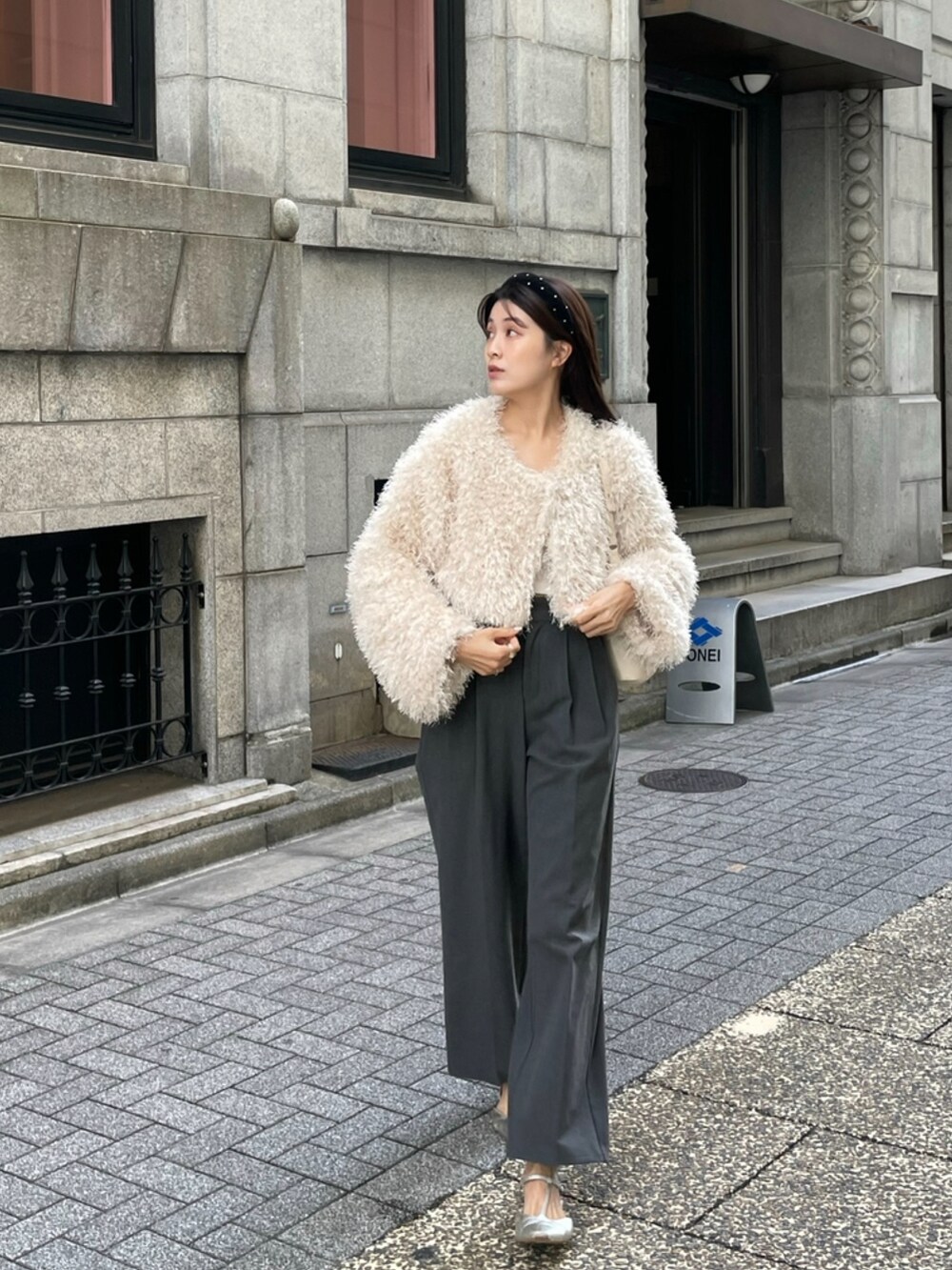 ベージュ系のブルゾン、グレー系のパンツ、ブラック系のカチューシャを着用したレディースの秋コーディネートの3枚目の写真