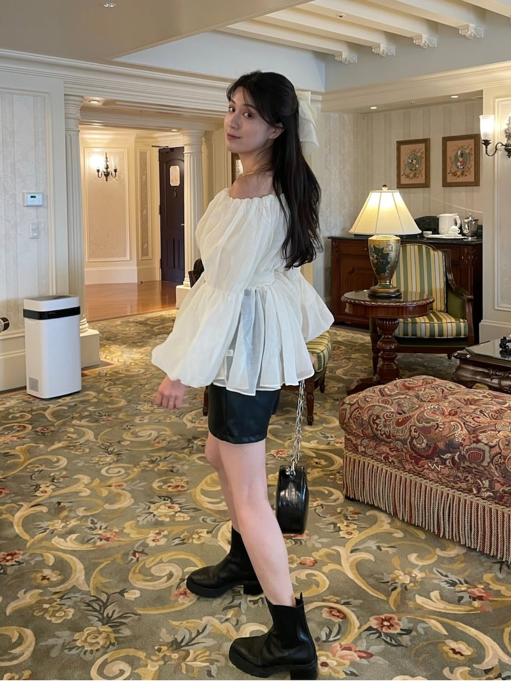 ホワイト系のトップス、ブラック系のショルダーバッグを着用したレディースの秋コーディネートの2枚目の写真