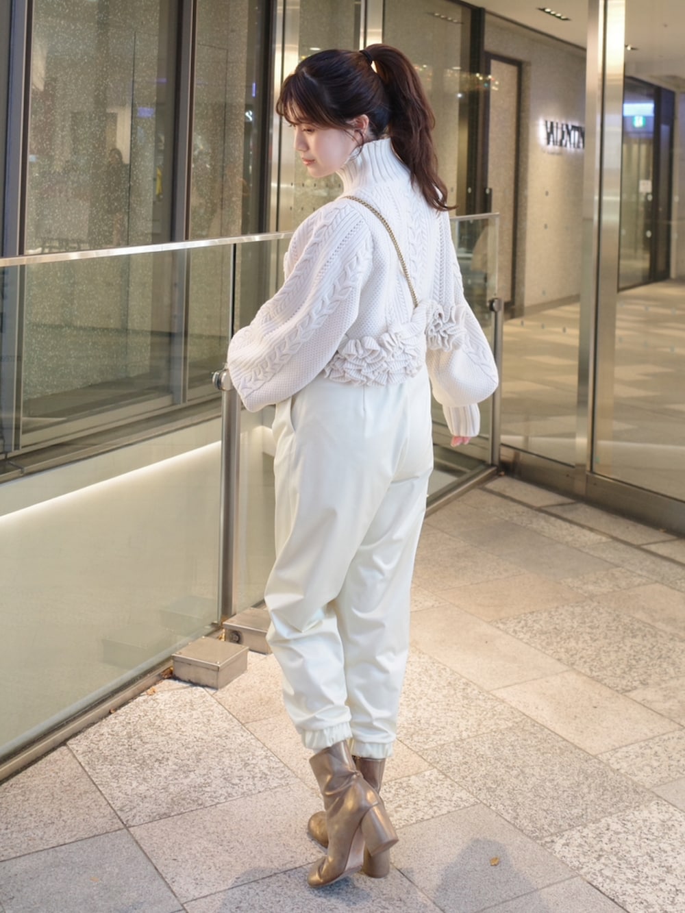 ホワイト系のニット/セーター、ベージュ系のその他パンツ、ゴールド系のブーツを着用したレディースの秋コーディネートの2枚目の写真