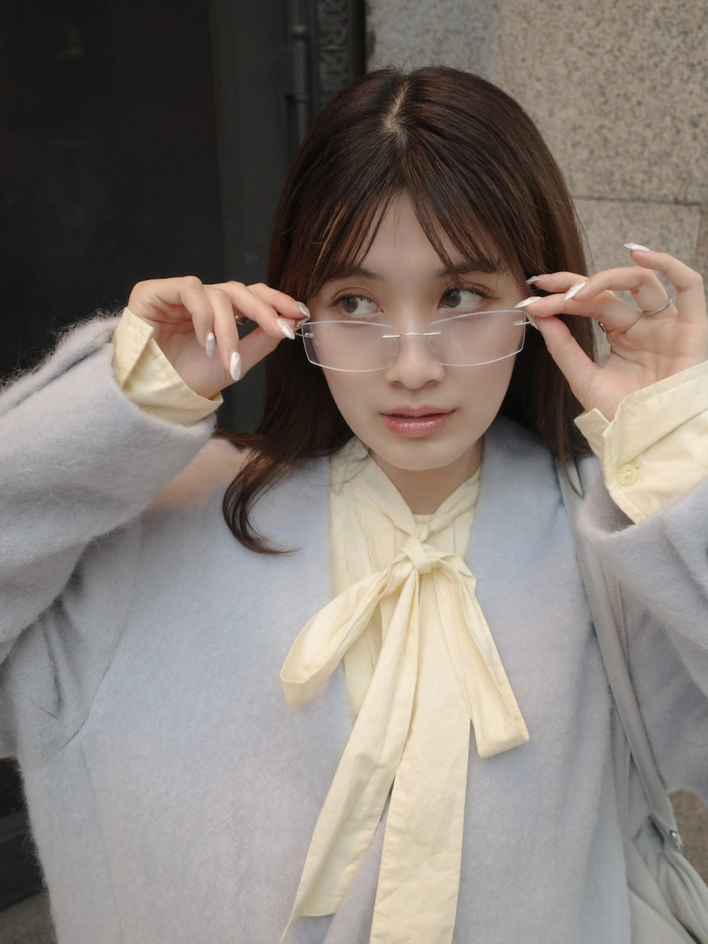 イエロー系のトップス、ブルー系のテーラードジャケットを着用したレディースの秋コーディネートの3枚目の写真