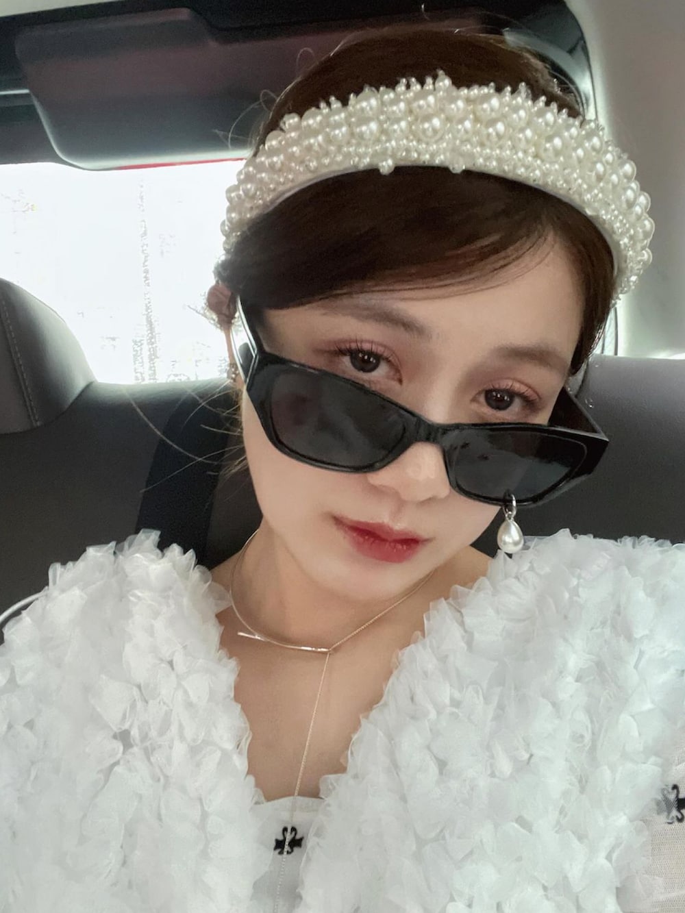 ホワイト系のワンピース/ドレス、ホワイト系のハンドバッグ、ホワイト系のTシャツ/カットソーを着用したレディースの夏コーディネートの3枚目の写真