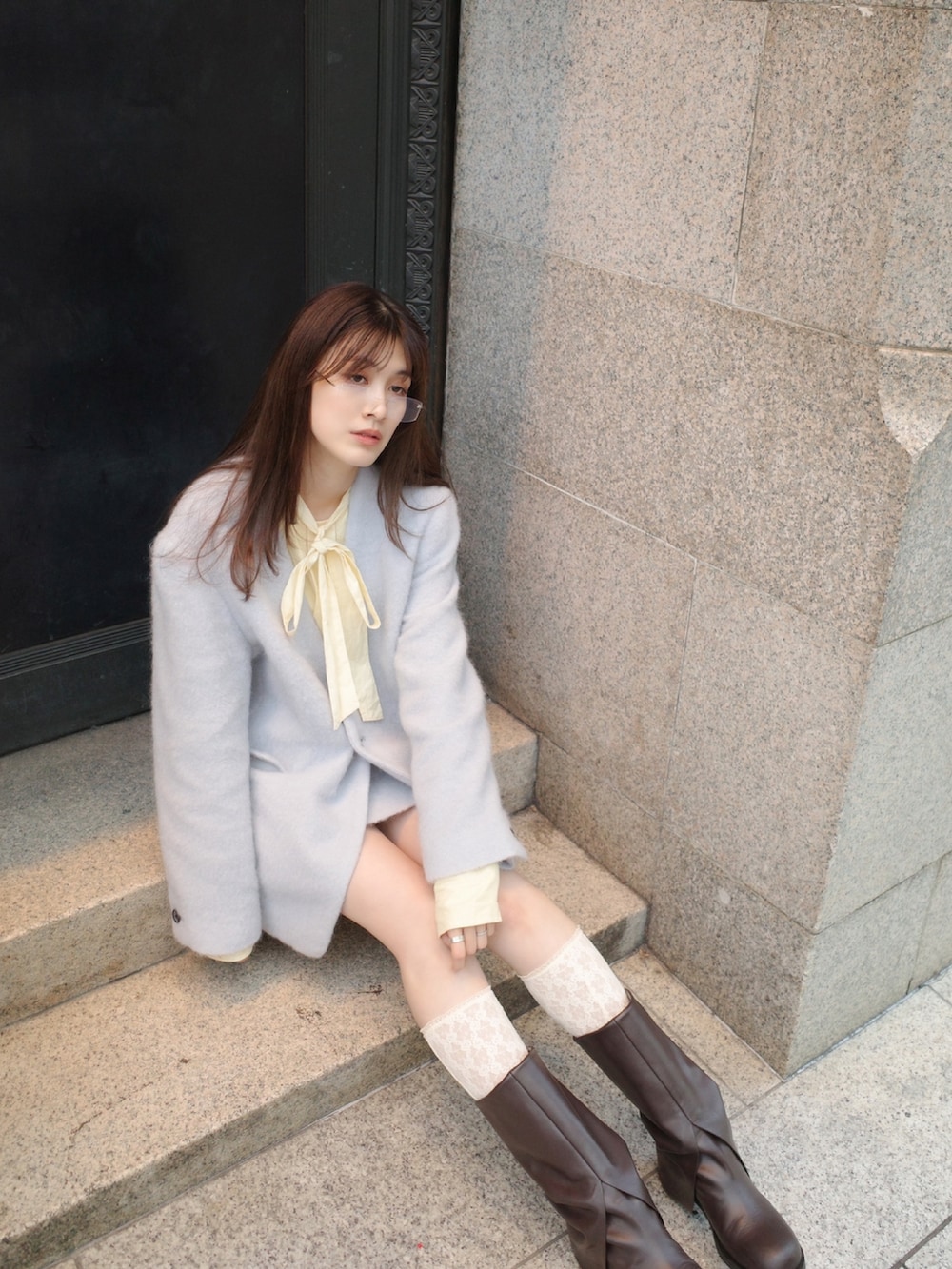 イエロー系のトップス、ブルー系のテーラードジャケットを着用したレディースの秋コーディネートの2枚目の写真