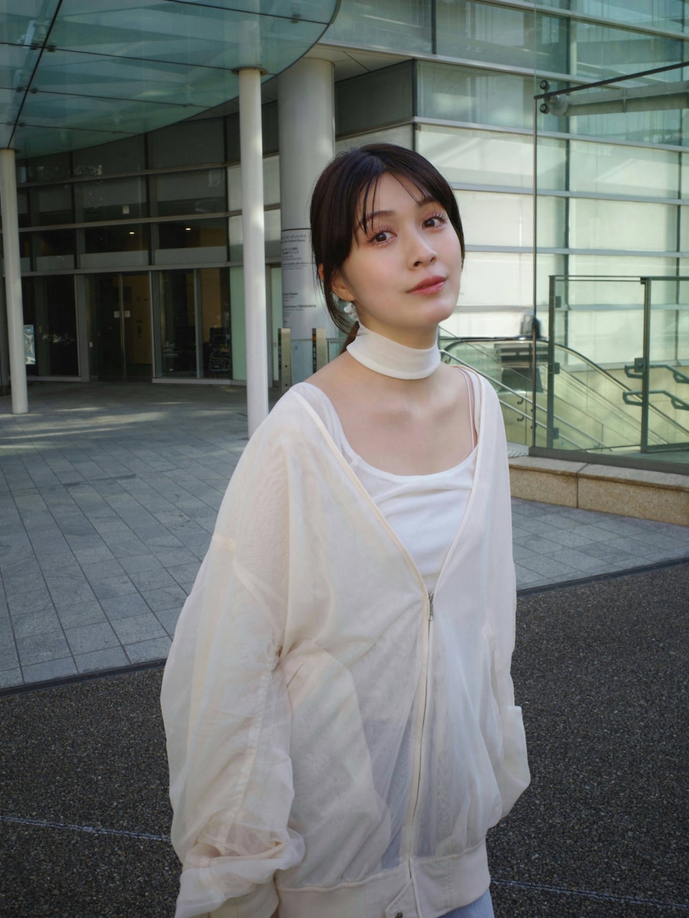 ホワイト系のTシャツ/カットソー、ホワイト系のブルゾン、ブルー系のデニムパンツを着用したレディースの冬コーディネートの2枚目の写真