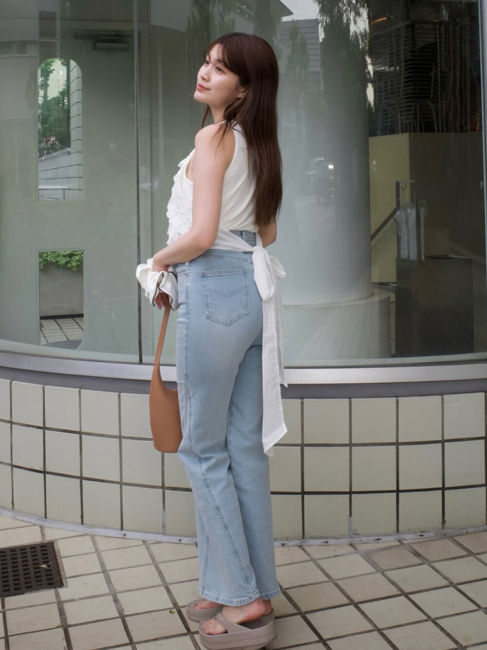 ホワイト系のトップス、ブラウン系のバッグ、ベージュ系のサンダルを着用したレディースの夏コーディネートの3枚目の写真