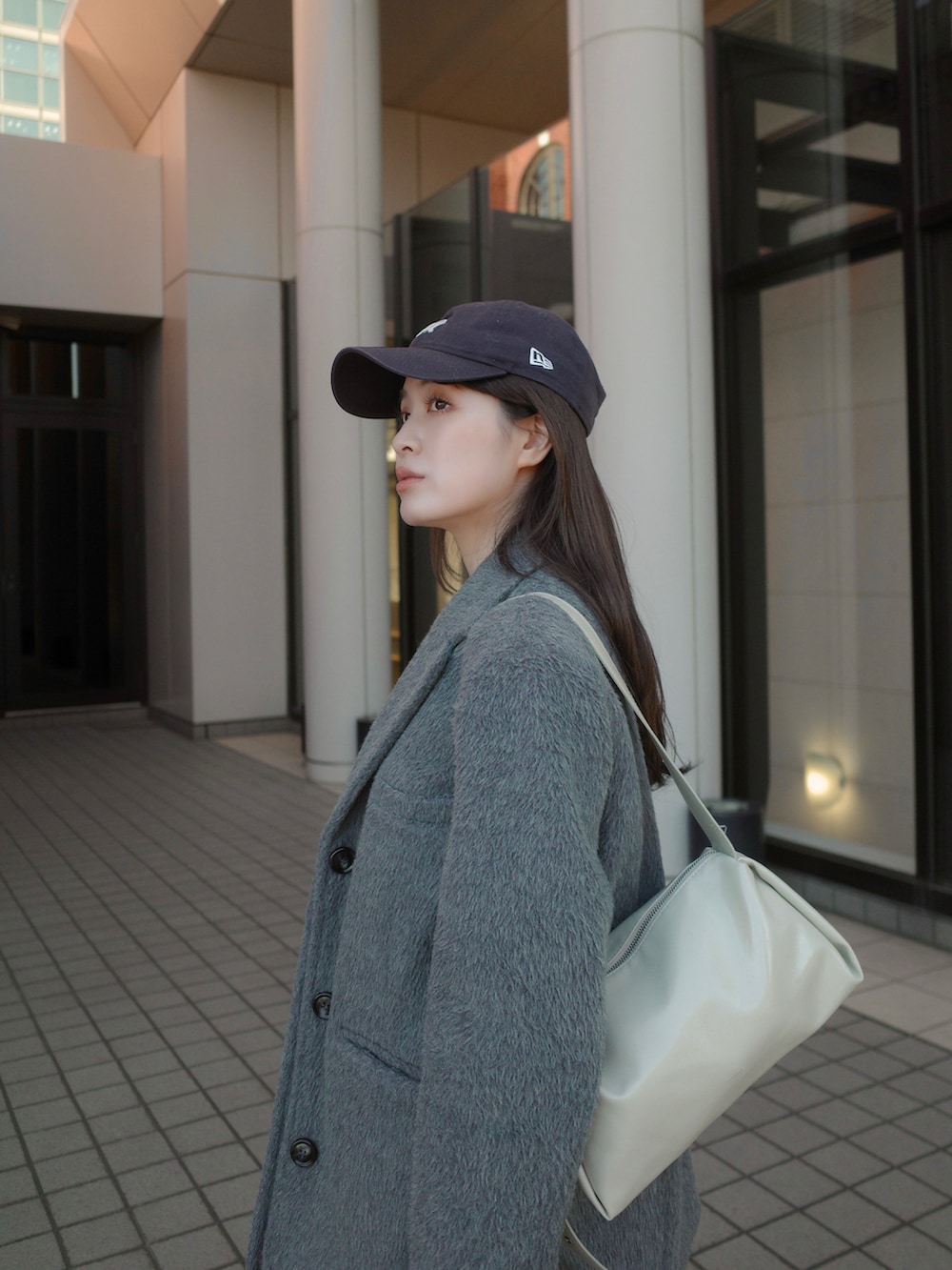 グレー系のテーラードジャケット、ホワイト系のスニーカーを着用したレディースの冬コーディネートの3枚目の写真