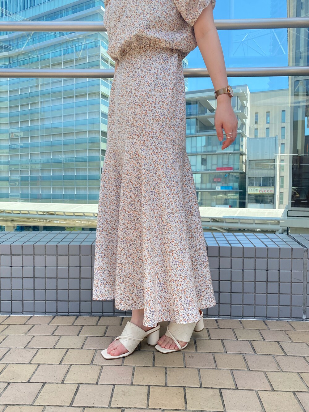 ホワイト系のサンダル、ブラック系のショルダーバッグ、ベージュ系のワンピースを着用したレディースの春コーディネートの3枚目の写真