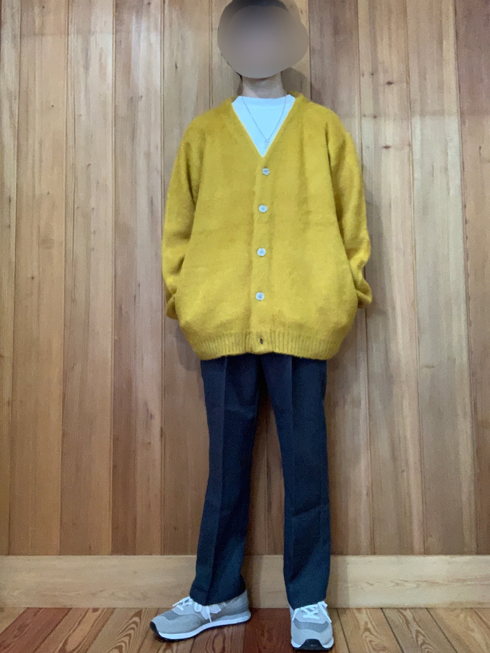 イエロー系のカーディガン/ボレロ、ホワイト系のTシャツ/カットソー、グレー系のスラックスを着用したメンズの冬コーディネートの2枚目の写真