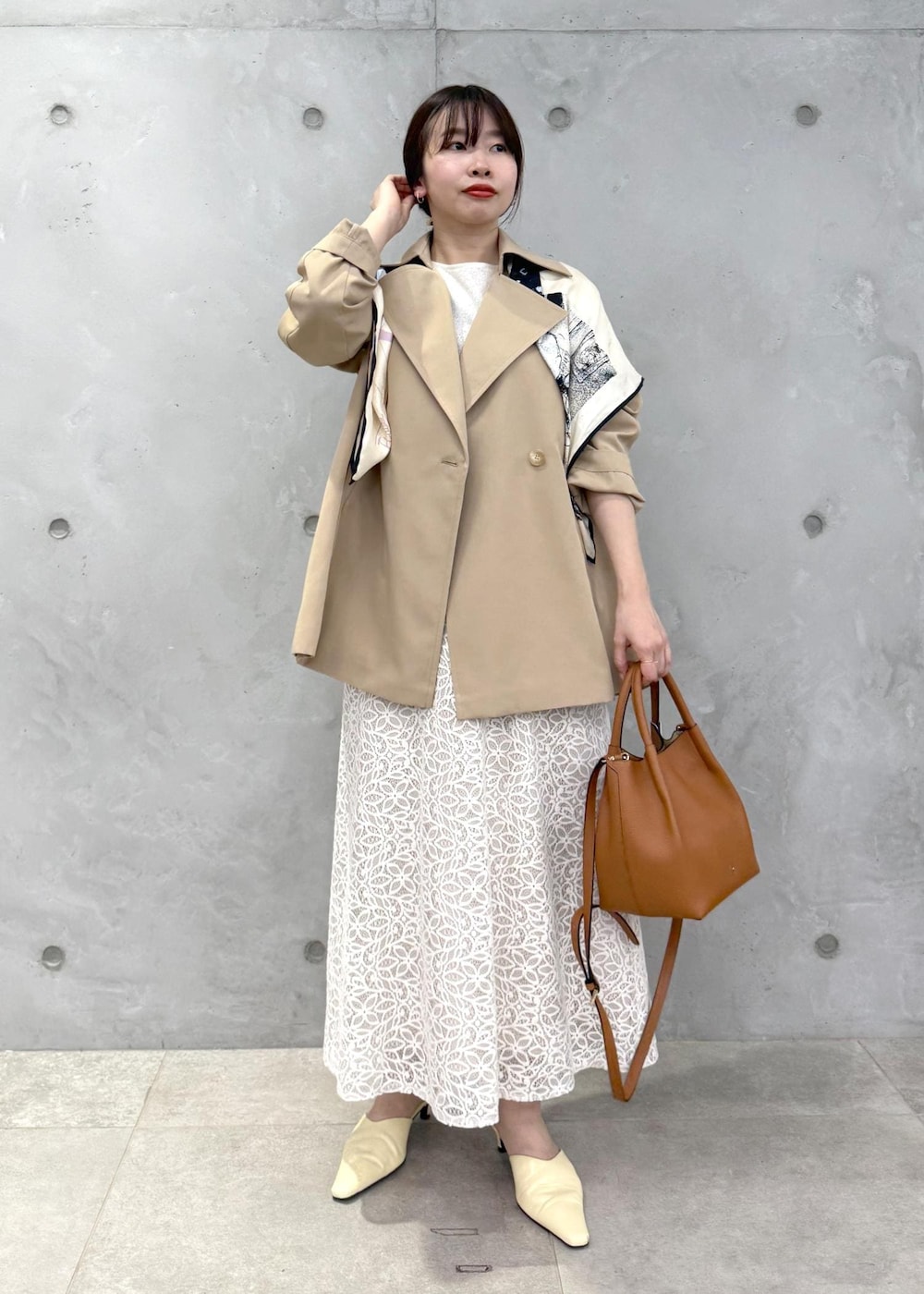 ホワイト系のTシャツ/カットソー、ベージュ系のトレンチコート、イエロー系のハンドバッグを着用したレディースの春コーディネートの2枚目の写真