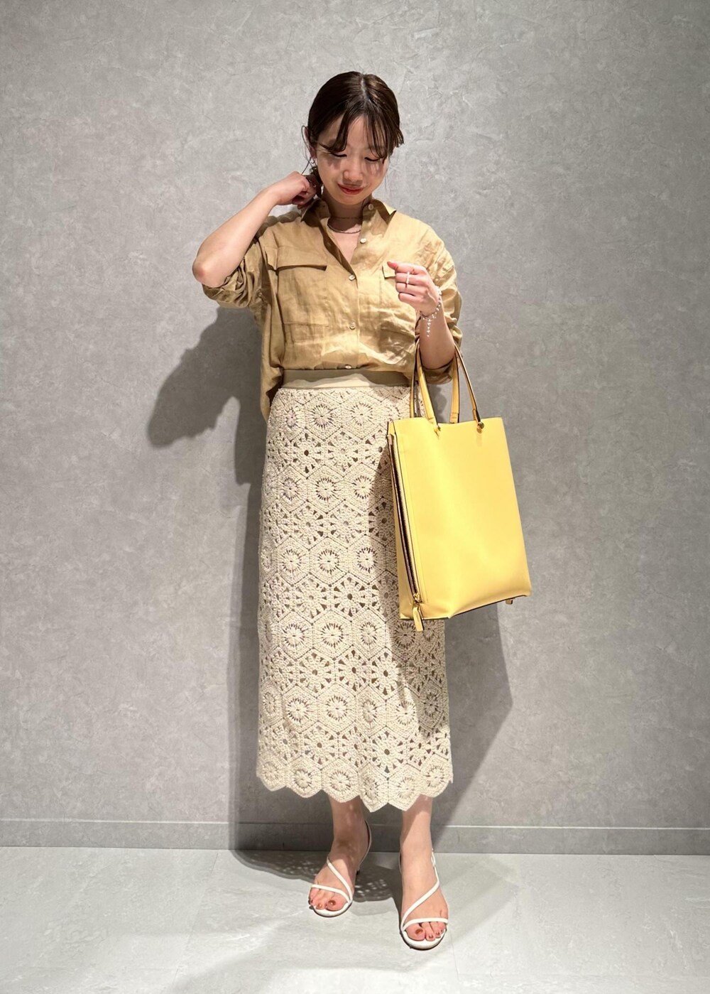 ベージュ系のシャツ/ブラウス、ホワイト系のスカート、イエロー系のバッグを着用したレディースの春コーディネートの2枚目の写真