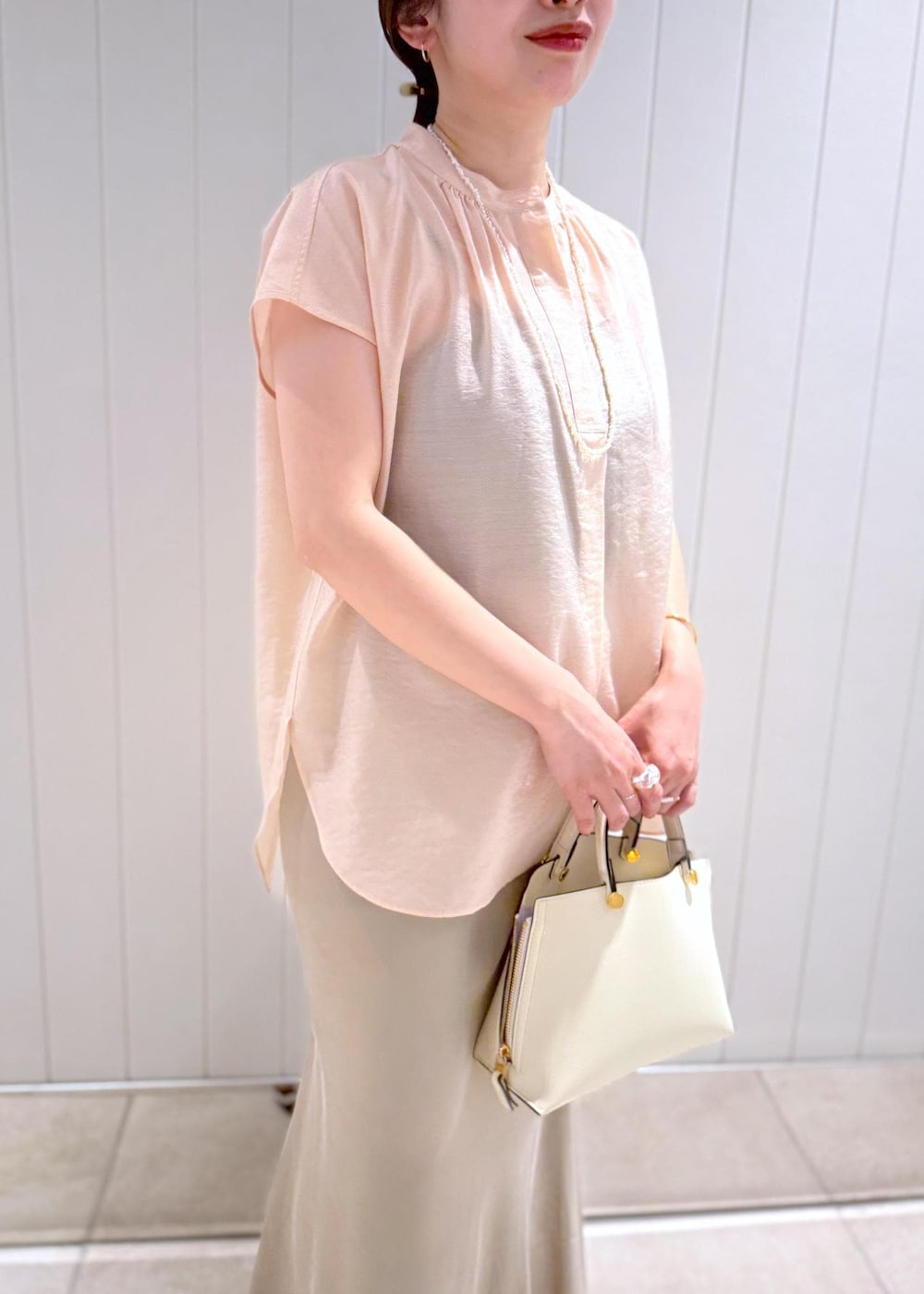 ベージュ系のスカート、ピンク系のシャツ/ブラウス、ホワイト系のハンドバッグを着用したレディースの夏コーディネートの7枚目の写真