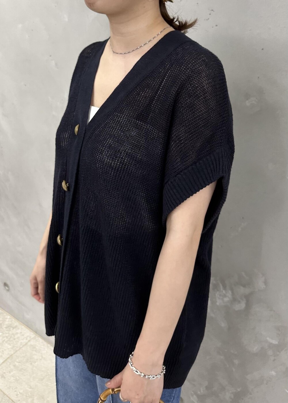 ブルー系のベスト、ブルー系のデニムパンツ、ホワイト系のサンダルを着用したレディースの春コーディネートの5枚目の写真