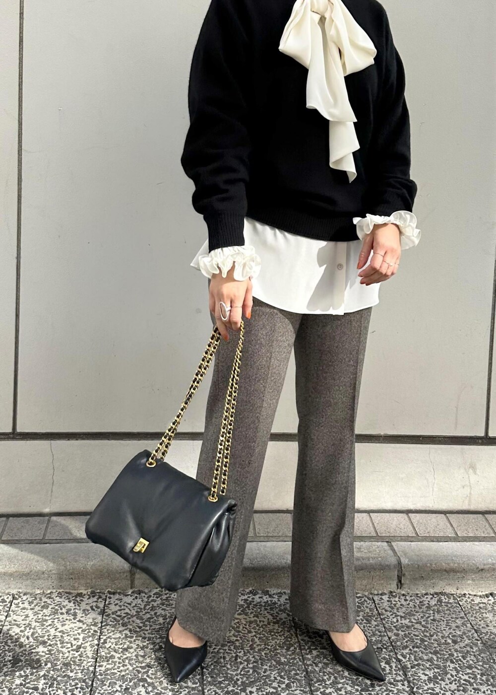 ブラック系のハンドバッグ、ブラック系のパンプス、グレー系のその他パンツを着用したレディースの秋コーディネートの7枚目の写真