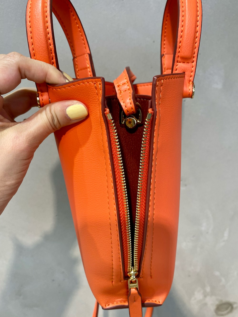 ホワイト系のノーカラージャケット、ブルー系のシャツ/ブラウス、オレンジ系のショルダーバッグを着用したレディースの春コーディネートの5枚目の写真