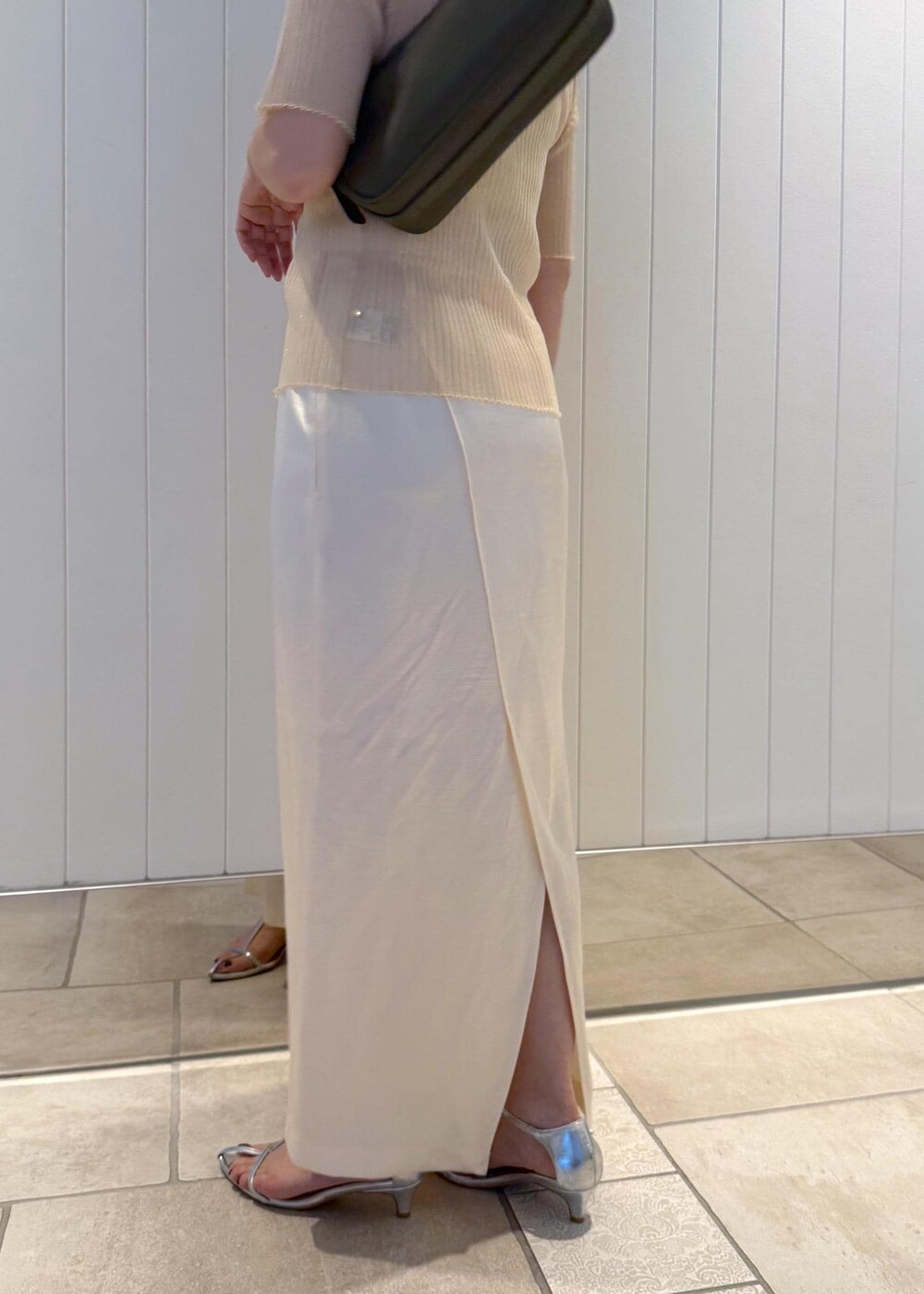ホワイト系のスカート、ベージュ系のニット/セーター、グリーン系のハンドバッグを着用したレディースの夏コーディネートの7枚目の写真