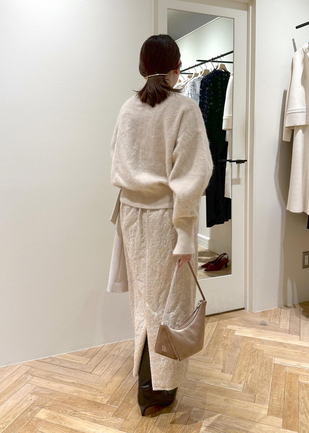 ブラック系のブーツ、ベージュ系のスカート、ベージュ系のニット/セーターを着用したレディースの冬コーディネートの2枚目の写真