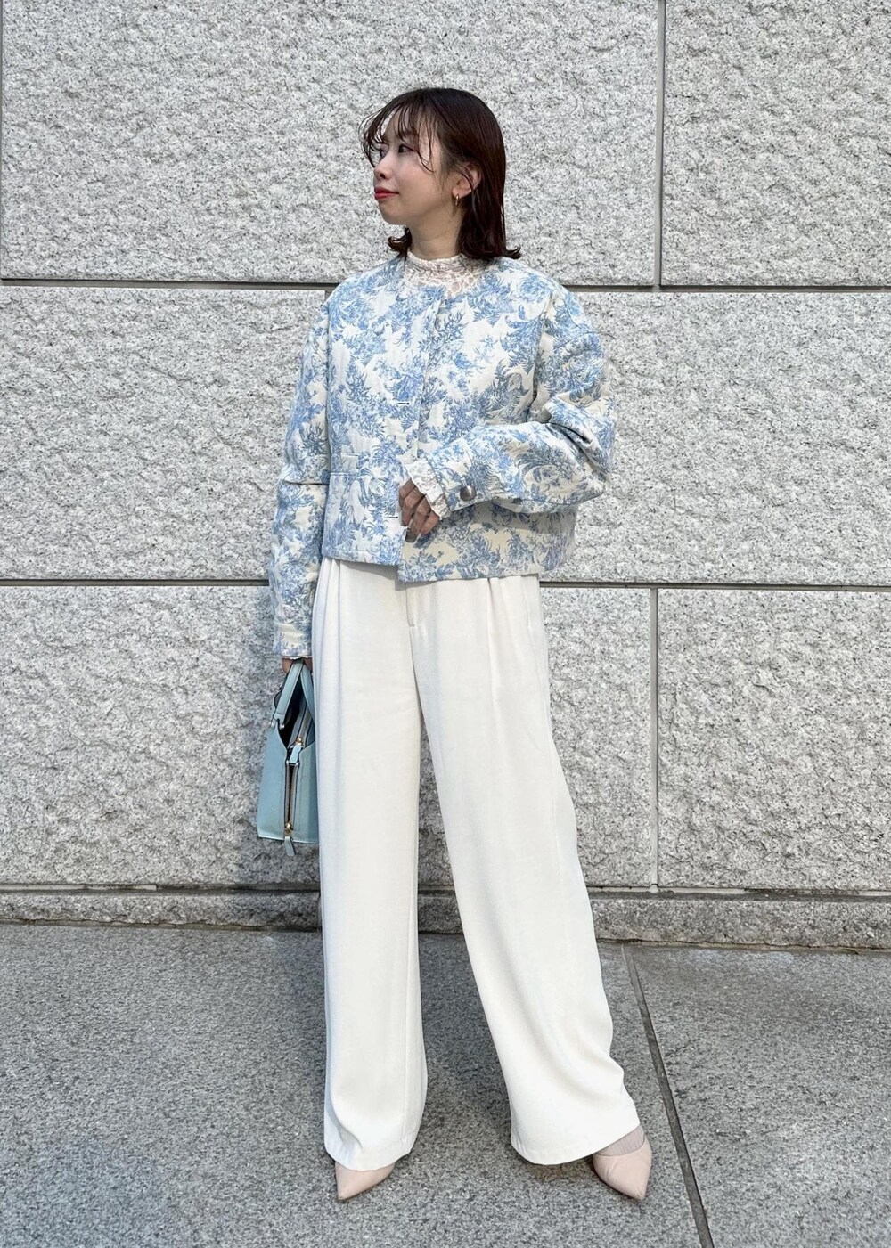 ブルー系のハンドバッグ、ベージュ系のパンプス、ホワイト系のその他パンツを着用したレディースの冬コーディネートの2枚目の写真