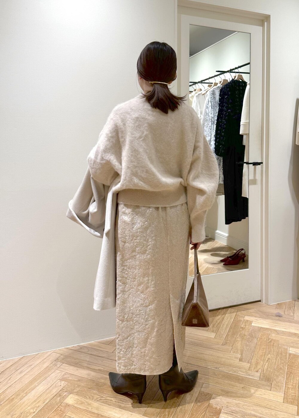 ブラック系のブーツ、ベージュ系のスカート、ベージュ系のニット/セーターを着用したレディースの冬コーディネートの4枚目の写真