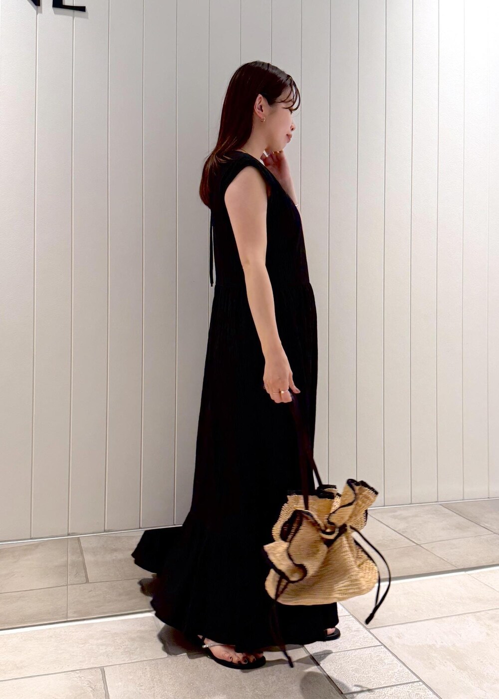 ブラック系のワンピース、ゴールド系のネックレスを着用したレディースの夏コーディネートの2枚目の写真