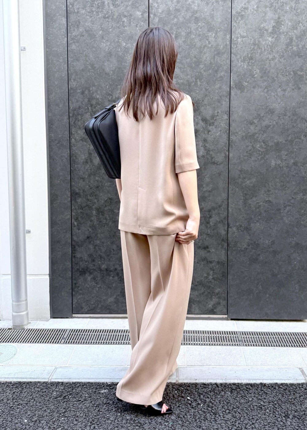 ベージュ系のその他パンツ、ベージュ系のテーラードジャケット、ブラック系のハンドバッグを着用したレディースの夏コーディネートの2枚目の写真