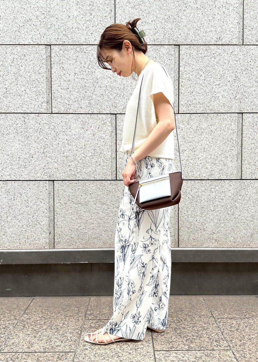 ブラウン系のショルダーバッグ、ホワイト系のサンダル、ホワイト系のその他パンツを着用したレディースの夏コーディネートの2枚目の写真