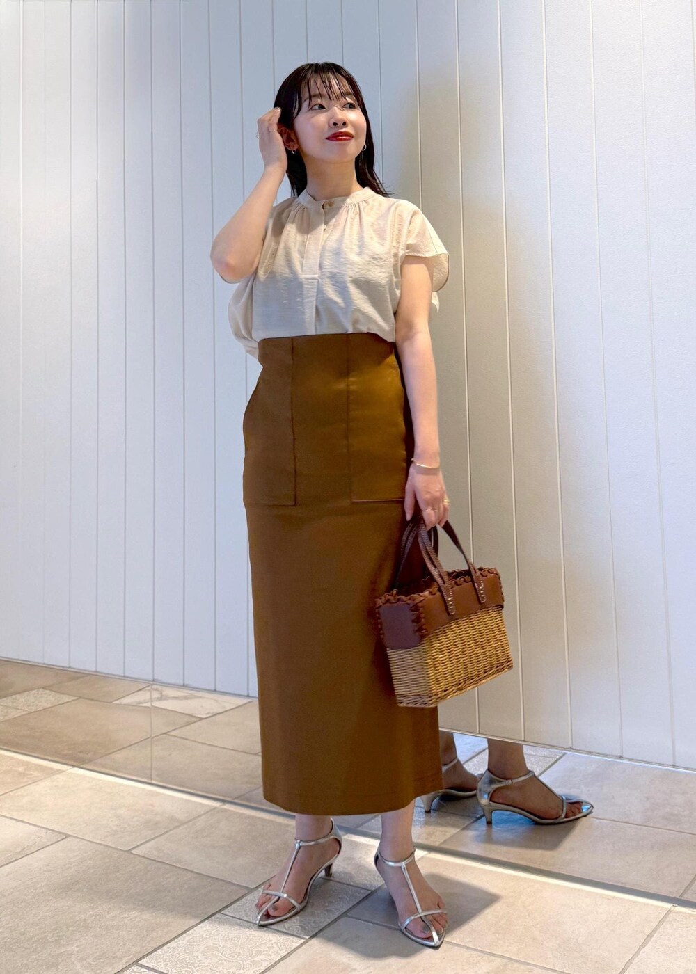 ブラウン系のスカート、ベージュ系のシャツ/ブラウスを着用したレディースの春コーディネートの2枚目の写真
