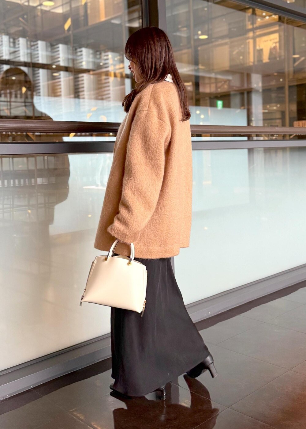 ホワイト系のハンドバッグ、ブラック系のスカート、ホワイト系のシャツ/ブラウスを着用したレディースの秋コーディネートの2枚目の写真