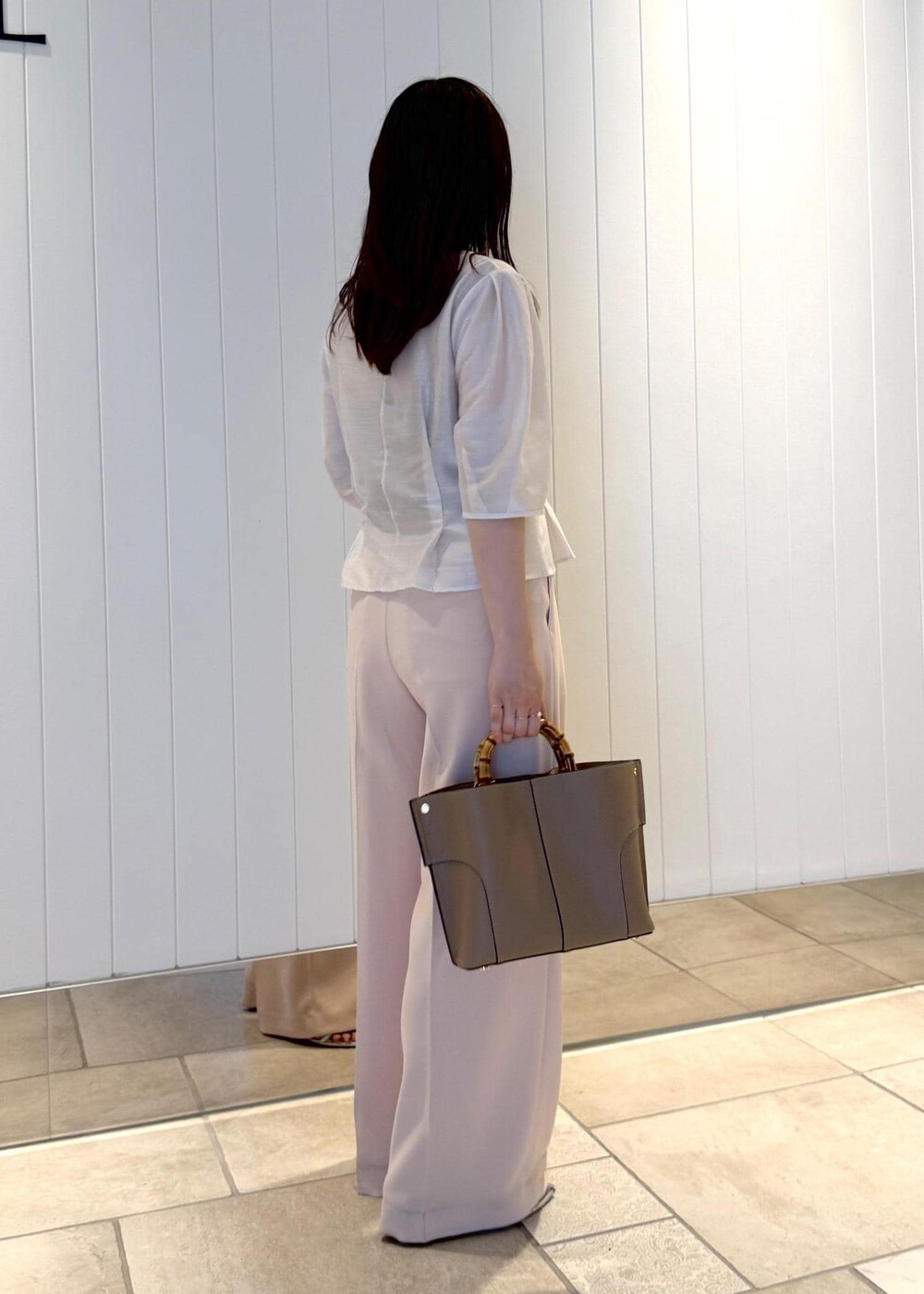 ピンク系のその他パンツ、ホワイト系のシャツ/ブラウス、ベージュ系のハンドバッグを着用したレディースの夏コーディネートの3枚目の写真