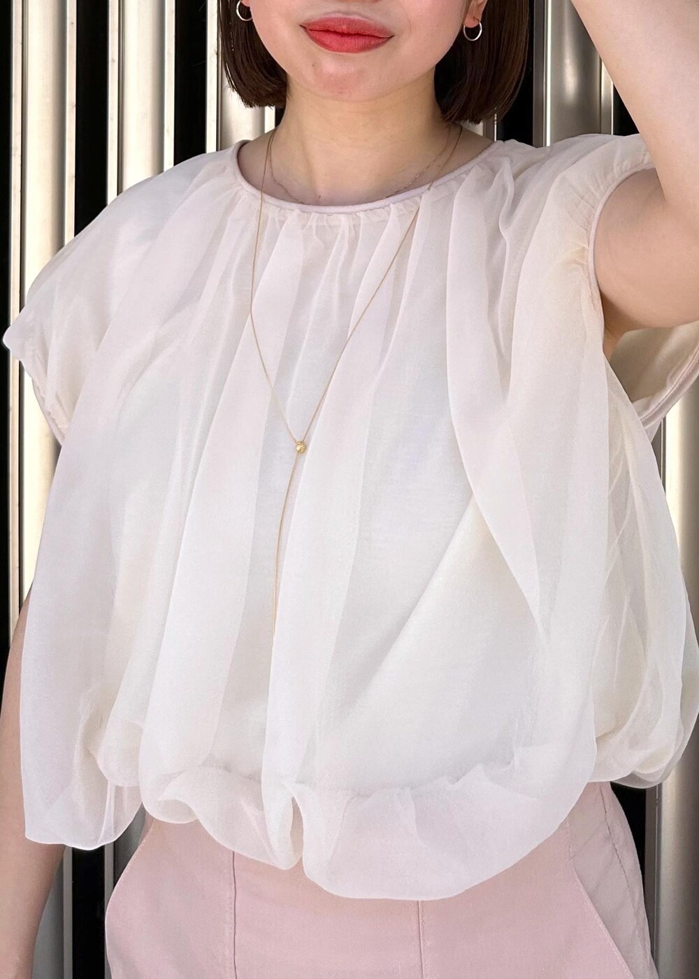 ピンク系のスカート、ホワイト系のTシャツ/カットソー、グレー系のハンドバッグを着用したレディースの夏コーディネートの6枚目の写真