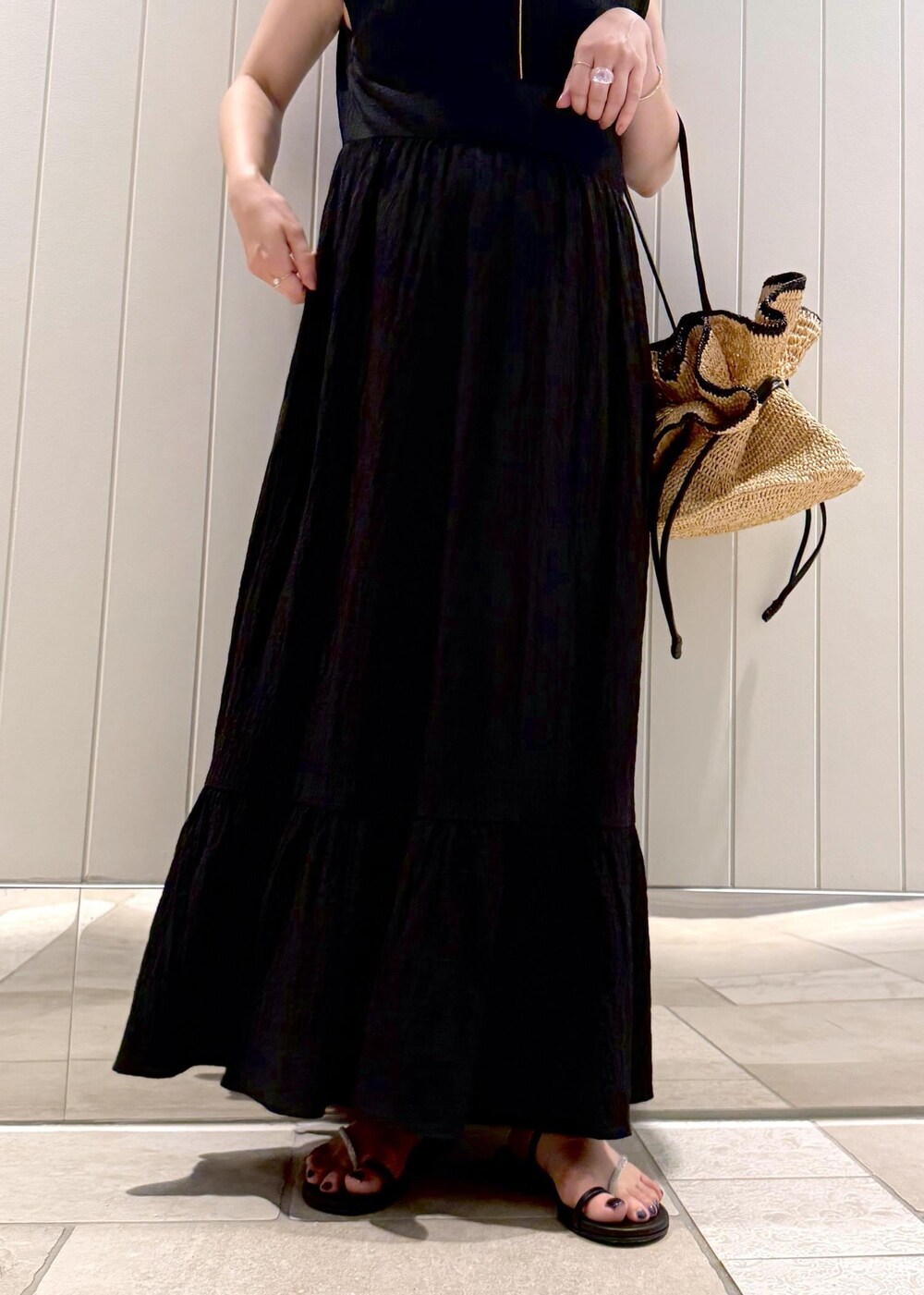 ブラック系のワンピース、ゴールド系のネックレスを着用したレディースの夏コーディネートの6枚目の写真