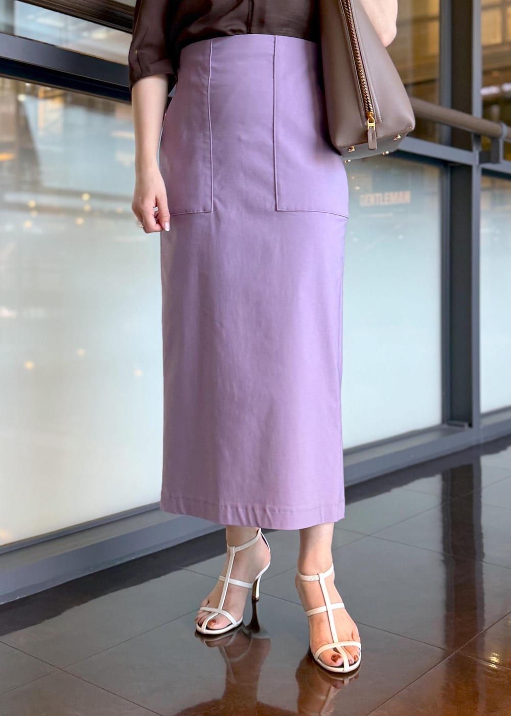 ブラウン系のトートバッグ、パープル系のスカート、ブラウン系のシャツ/ブラウスを着用したレディースの春コーディネートの7枚目の写真