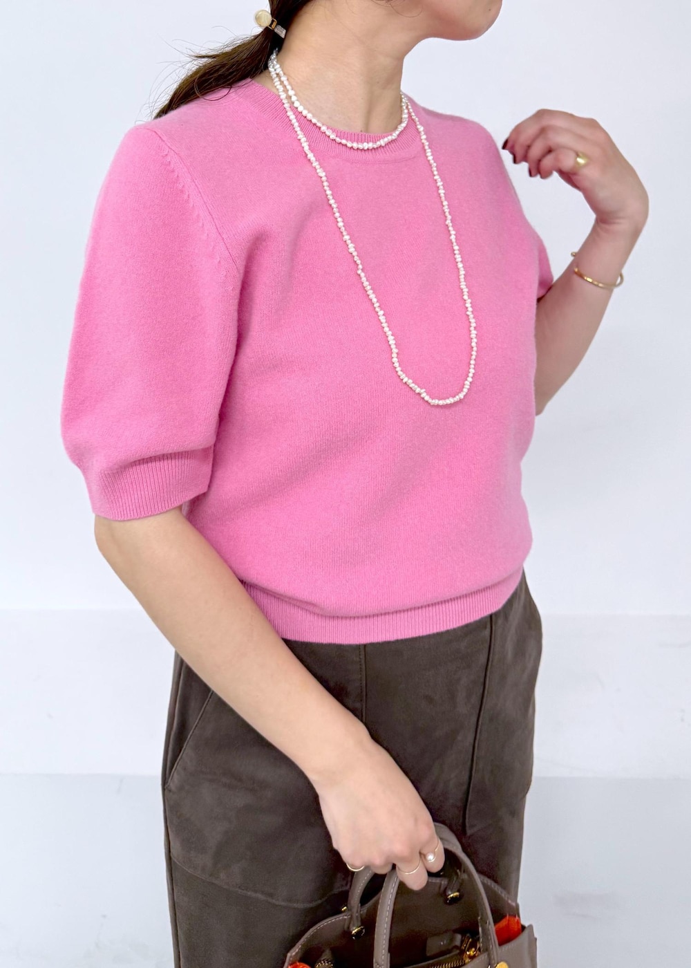 ブラック系のブーツ、ブラウン系のスカート、ブラウン系のハンドバッグを着用したレディースの秋コーディネートの7枚目の写真