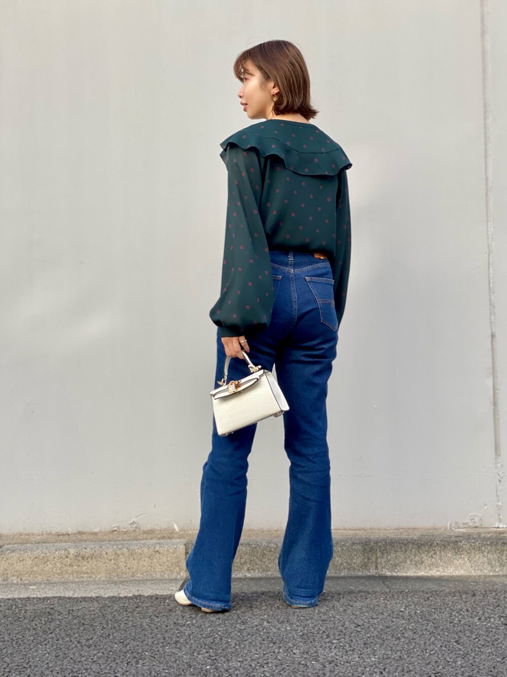グリーン系のシャツ/ブラウス、ブルー系のデニムパンツ、ホワイト系のパンプスを着用したレディースの冬コーディネートの3枚目の写真