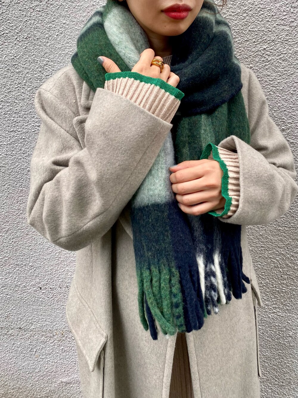 グレー系のチェスターコート、ベージュ系のスカート、ブラウン系のブーツを着用したレディースの冬コーディネートの5枚目の写真