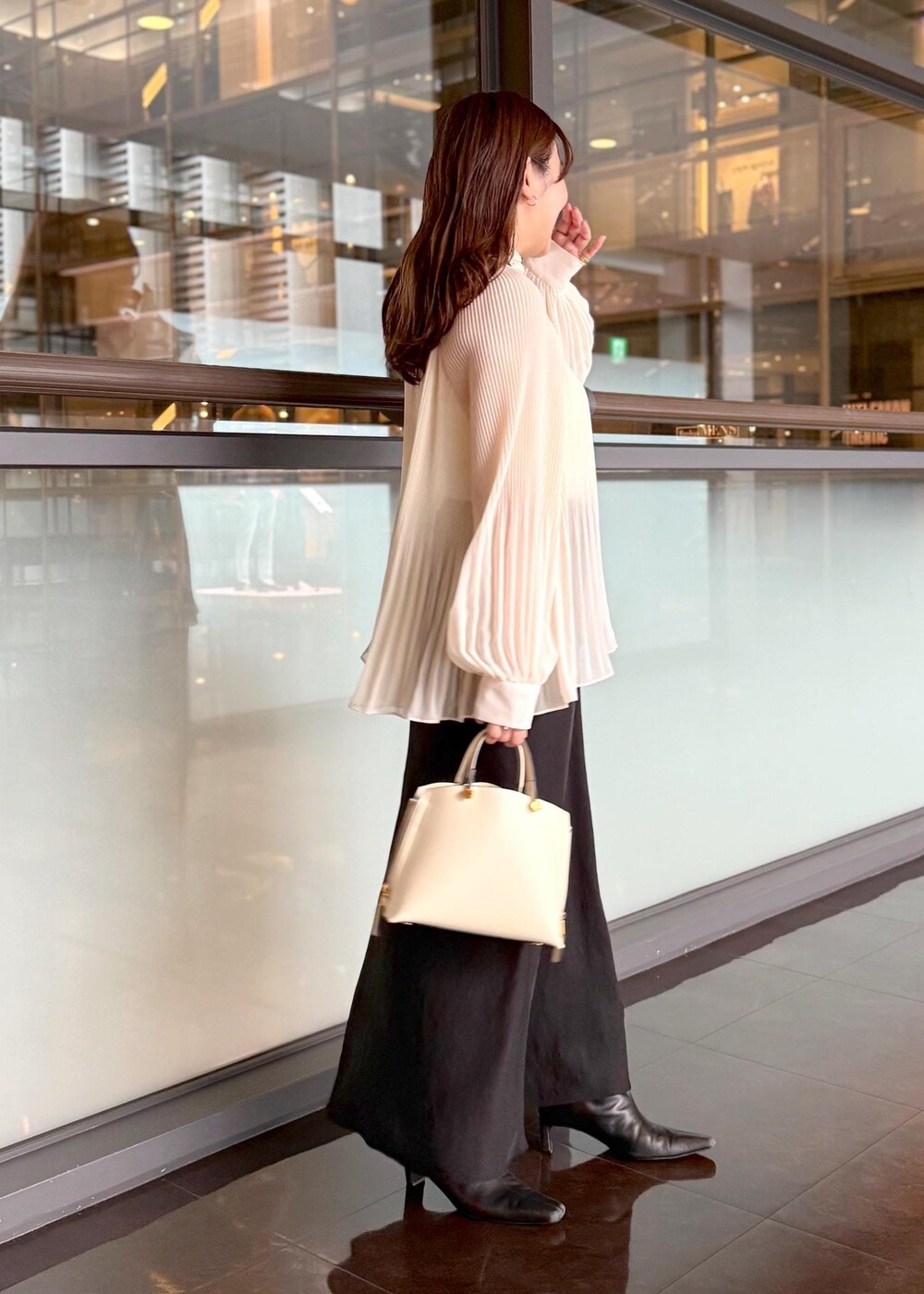 ホワイト系のハンドバッグ、ブラック系のスカート、ホワイト系のシャツ/ブラウスを着用したレディースの秋コーディネートの7枚目の写真