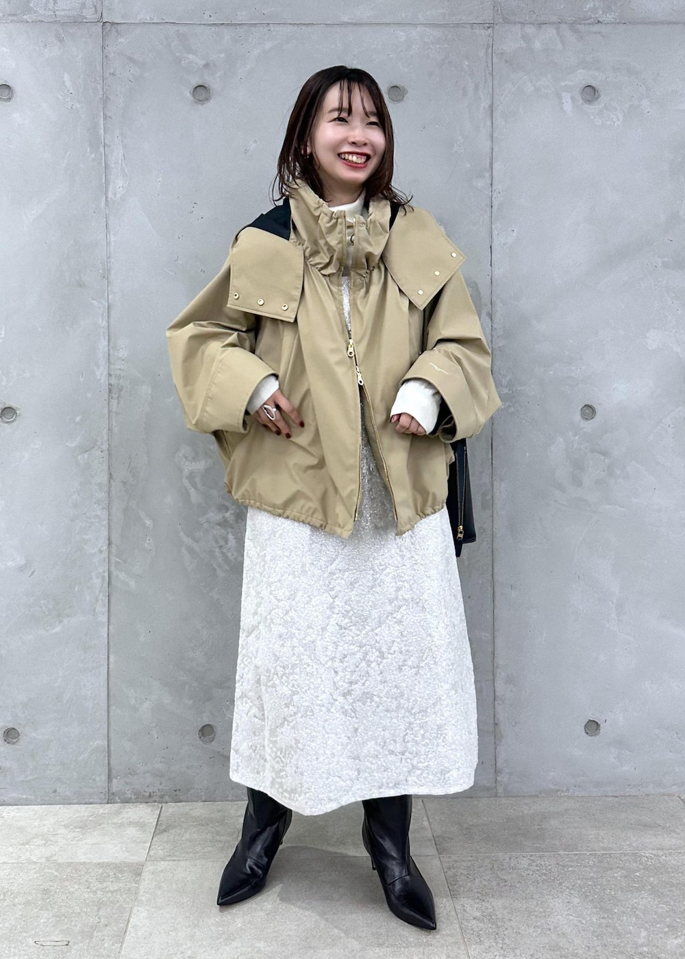 ブラック系のブーツ、ホワイト系のワンピース、ベージュ系のマウンテンパーカーを着用したレディースの秋コーディネートの9枚目の写真