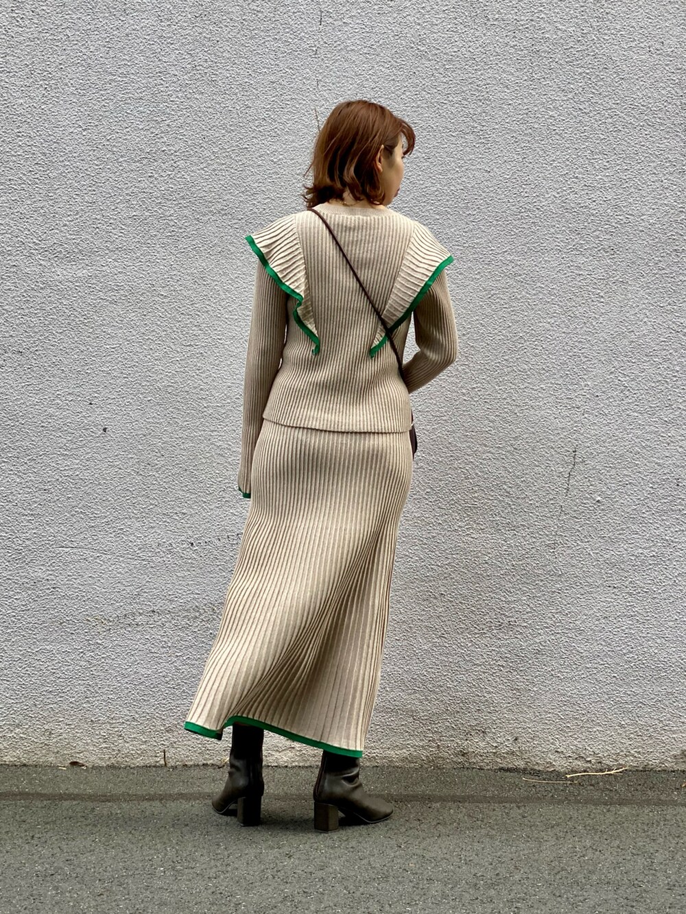 ベージュ系のニット/セーター、ベージュ系のスカート、ブラウン系のショルダーバッグを着用したレディースの冬コーディネートの3枚目の写真