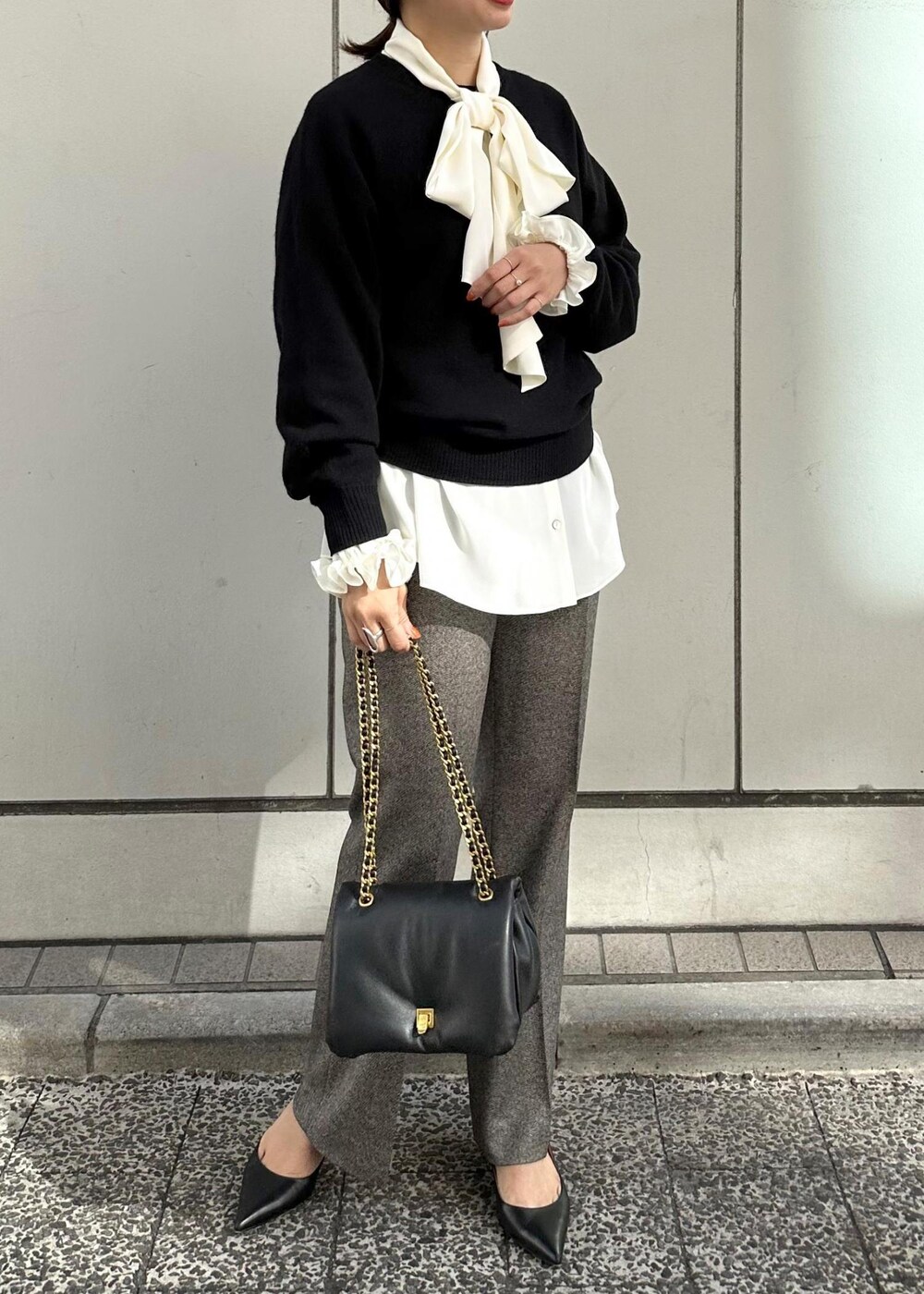 ブラック系のハンドバッグ、ブラック系のパンプス、グレー系のその他パンツを着用したレディースの秋コーディネートの3枚目の写真