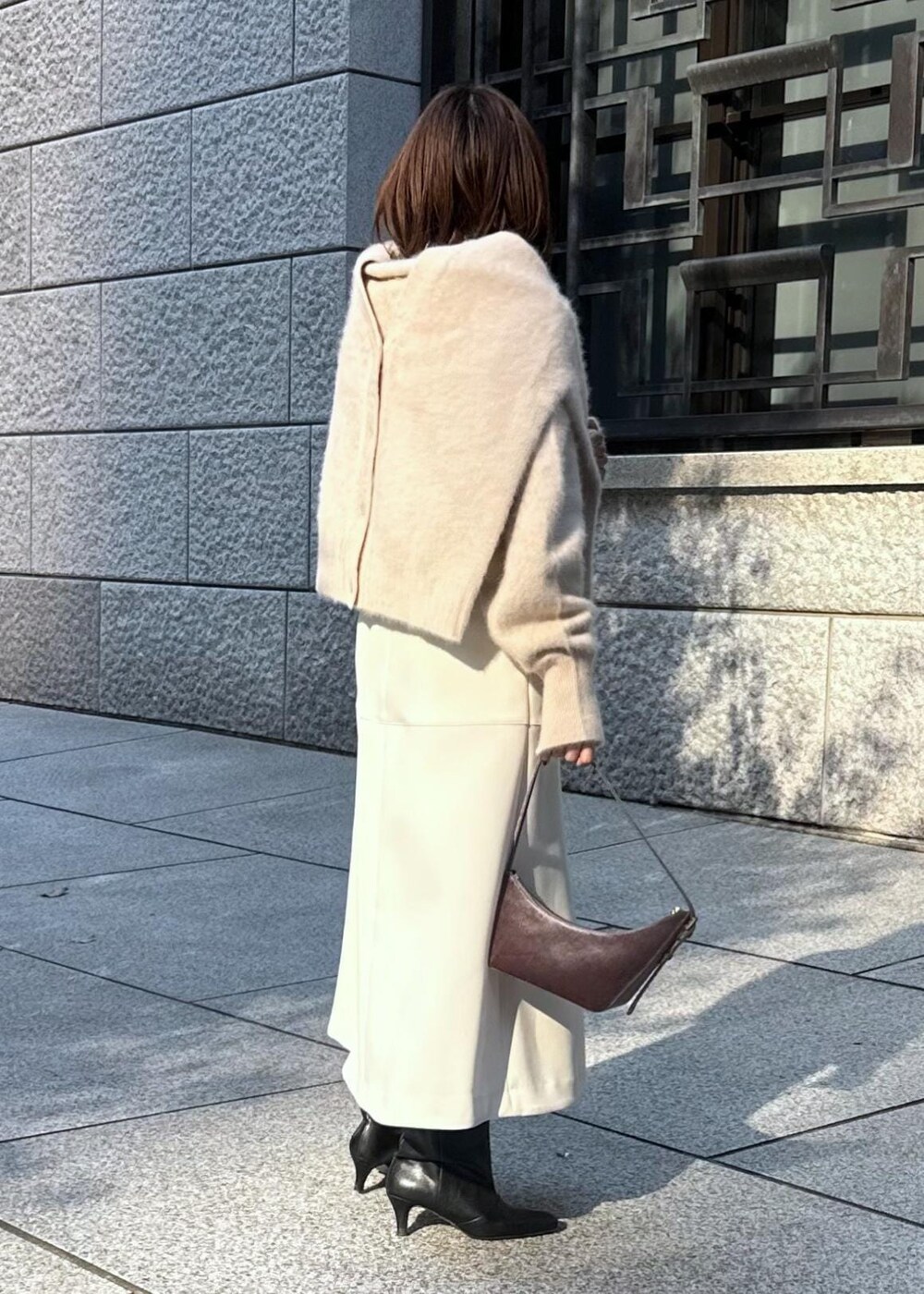 ホワイト系のスカート、ベージュ系のカーディガン/ボレロ、ベージュ系のニット/セーターを着用したレディースの秋コーディネートの4枚目の写真