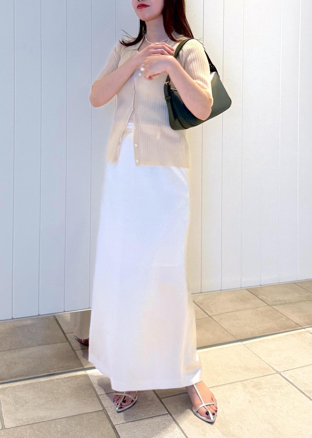 ホワイト系のスカート、ベージュ系のニット/セーター、グリーン系のハンドバッグを着用したレディースの夏コーディネートの8枚目の写真