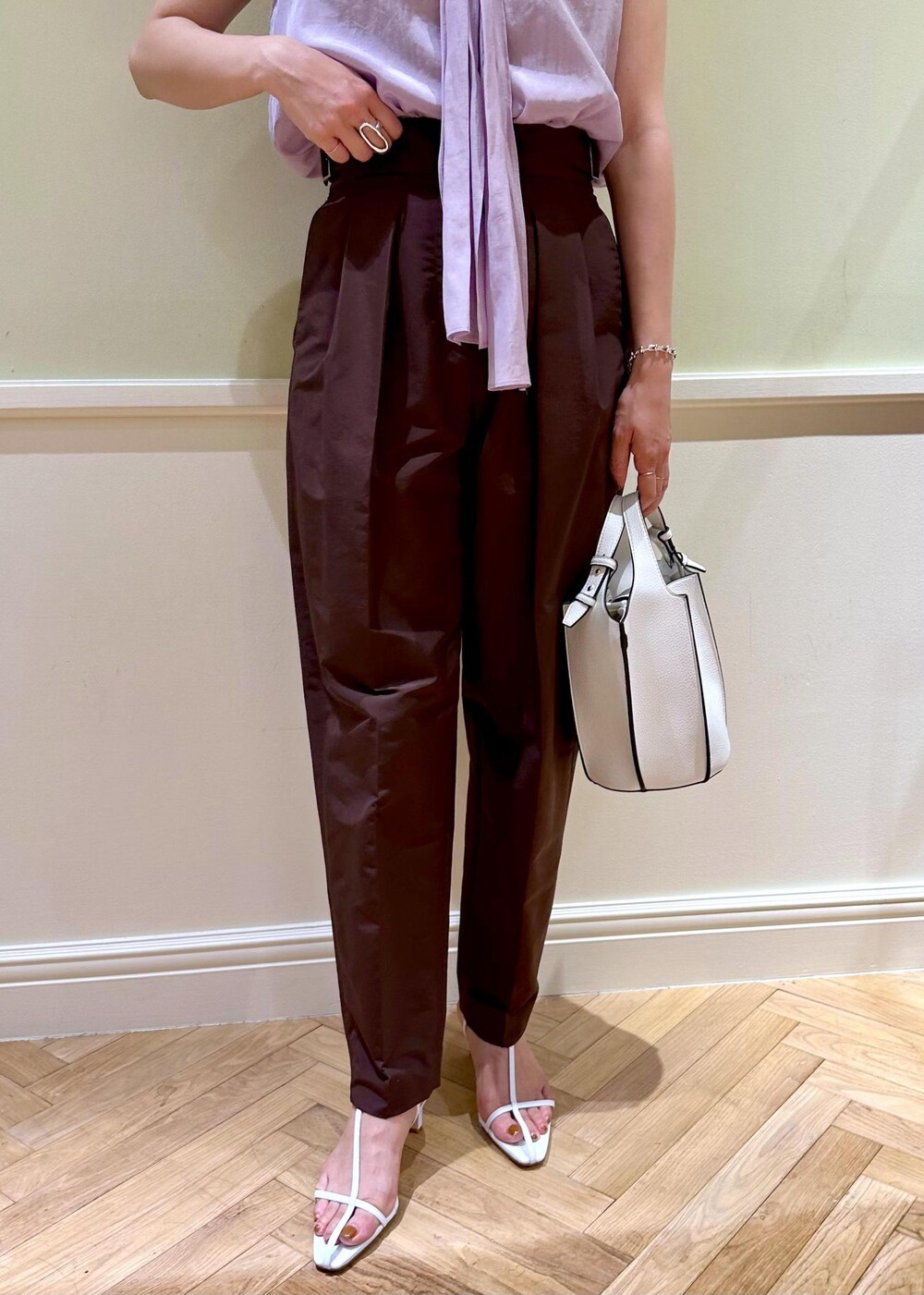 ホワイト系のハンドバッグ、パープル系のシャツ/ブラウス、ホワイト系のサンダルを着用したレディースの夏コーディネートの5枚目の写真