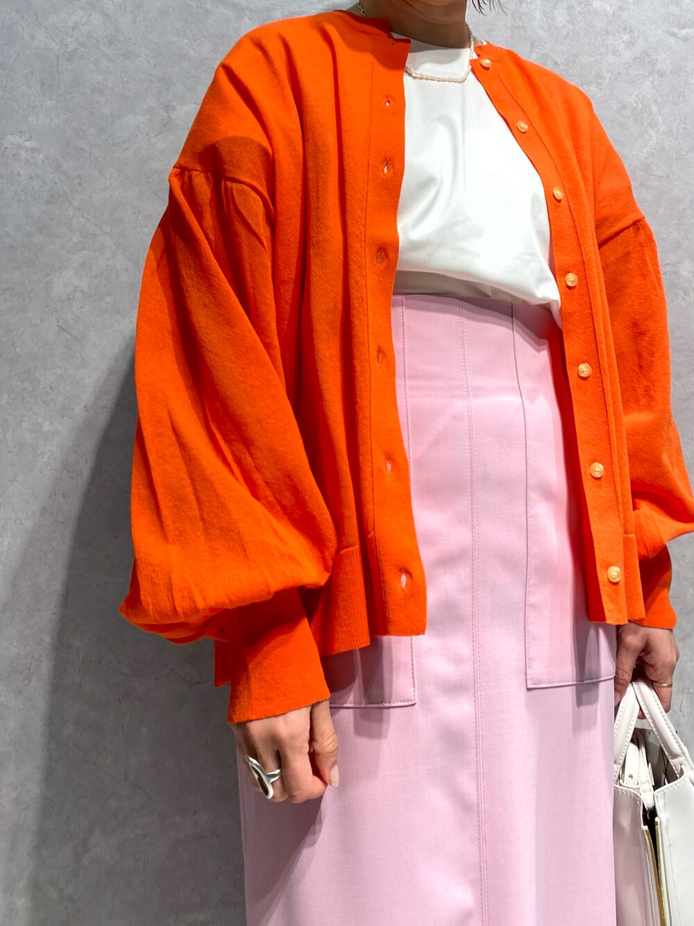 ホワイト系のショルダーバッグ、ホワイト系のサンダル、ピンク系のスカートを着用したレディースの春コーディネートの4枚目の写真