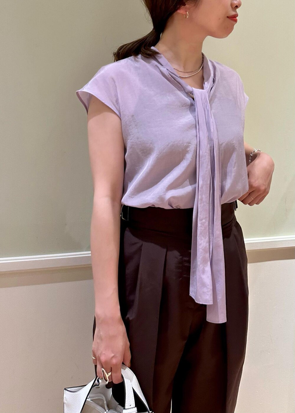 ホワイト系のハンドバッグ、パープル系のシャツ/ブラウス、ホワイト系のサンダルを着用したレディースの夏コーディネートの4枚目の写真