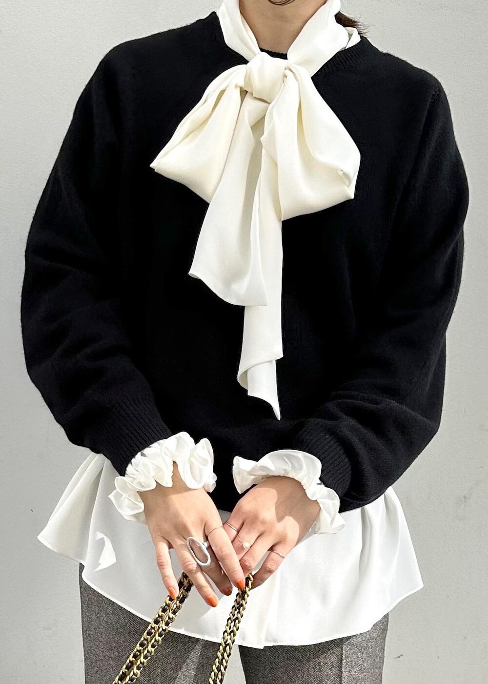 ブラック系のハンドバッグ、ブラック系のパンプス、グレー系のその他パンツを着用したレディースの秋コーディネートの5枚目の写真